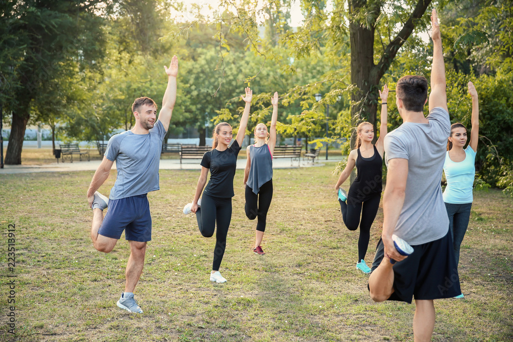 Group of sporty people training in park