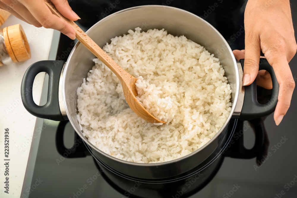 女人在炉子上用炖锅做饭