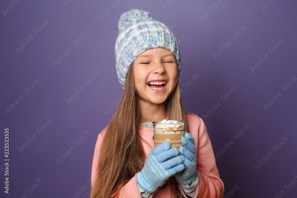 可爱的小女孩，穿着暖和的衣服，背景是一杯热巧克力