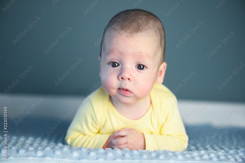 Newborn baby boy portrait on blue carpet closeup. Motherhood and new life concept