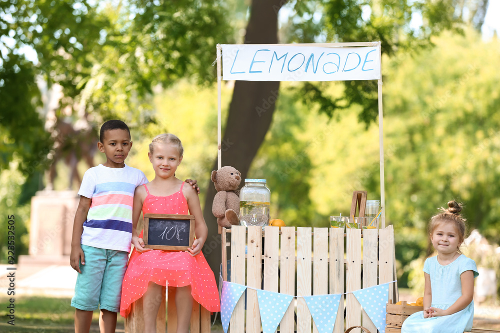 Little children near lemonade stand in park