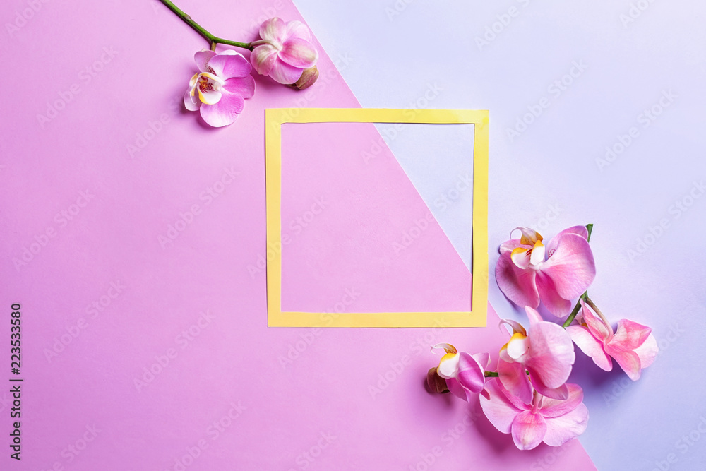 Composition with tropical flowers and frame on color background