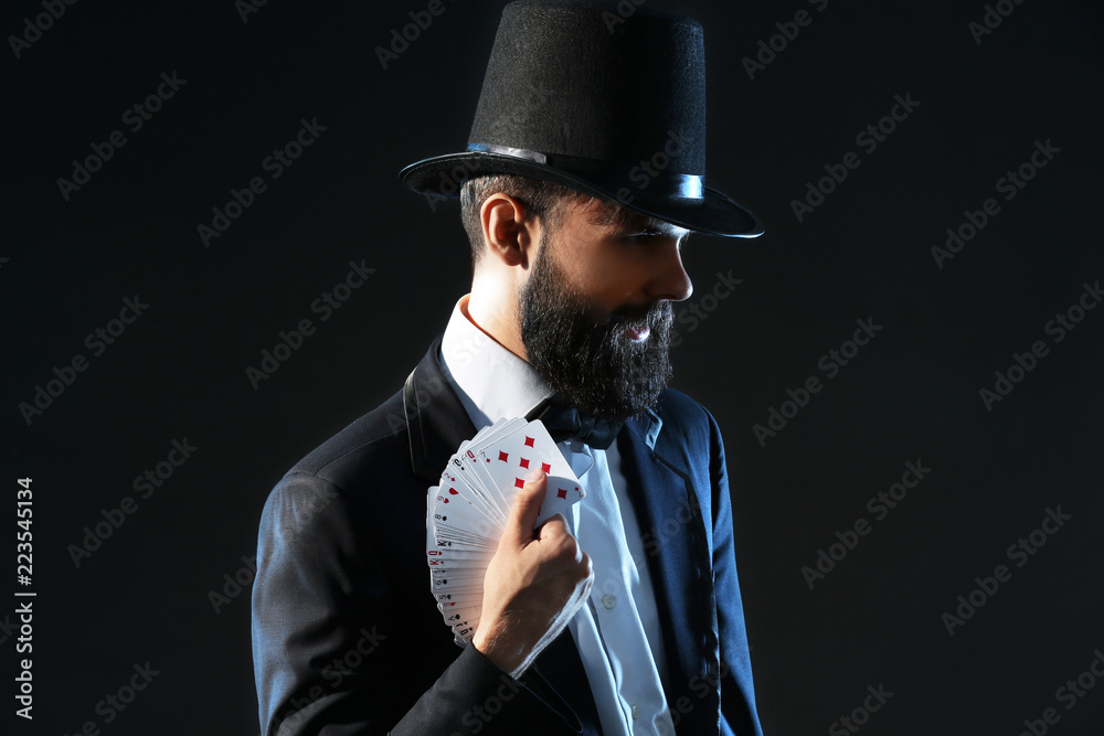 Magician with cards on dark background