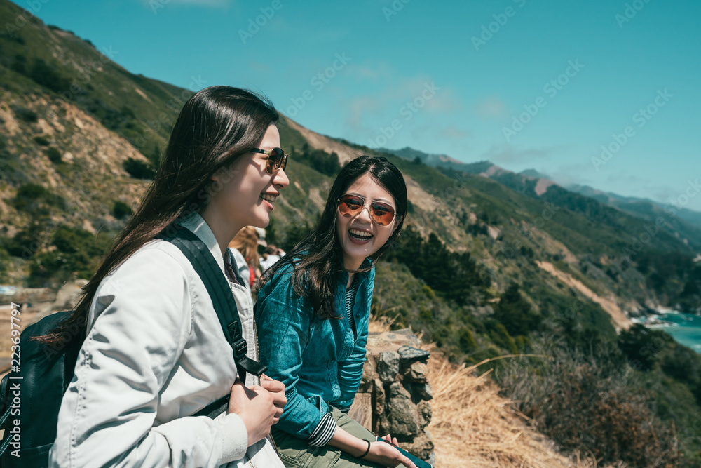 sisters laughing together happily and sitting