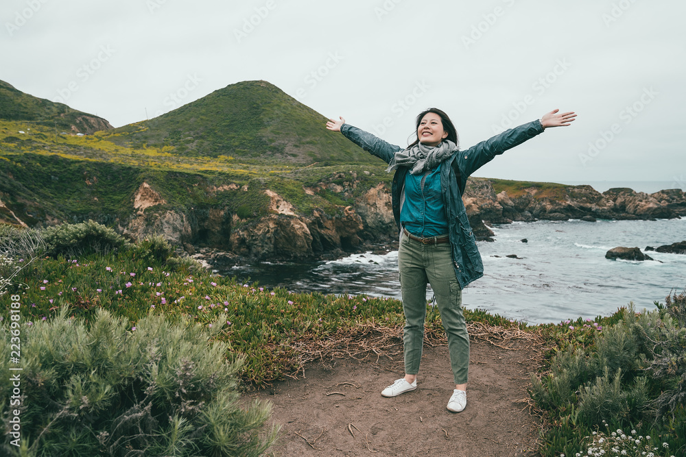 站在海岸上张开双臂的女人