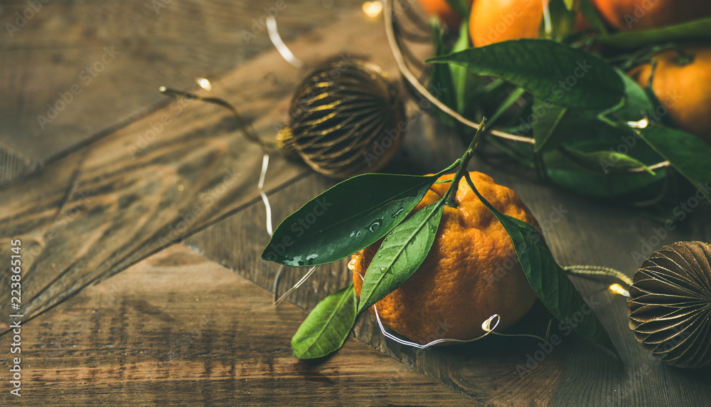 Christmas or New Year table. Fresh ripe tangerines with leaves in tray, decoration toys, scissors an