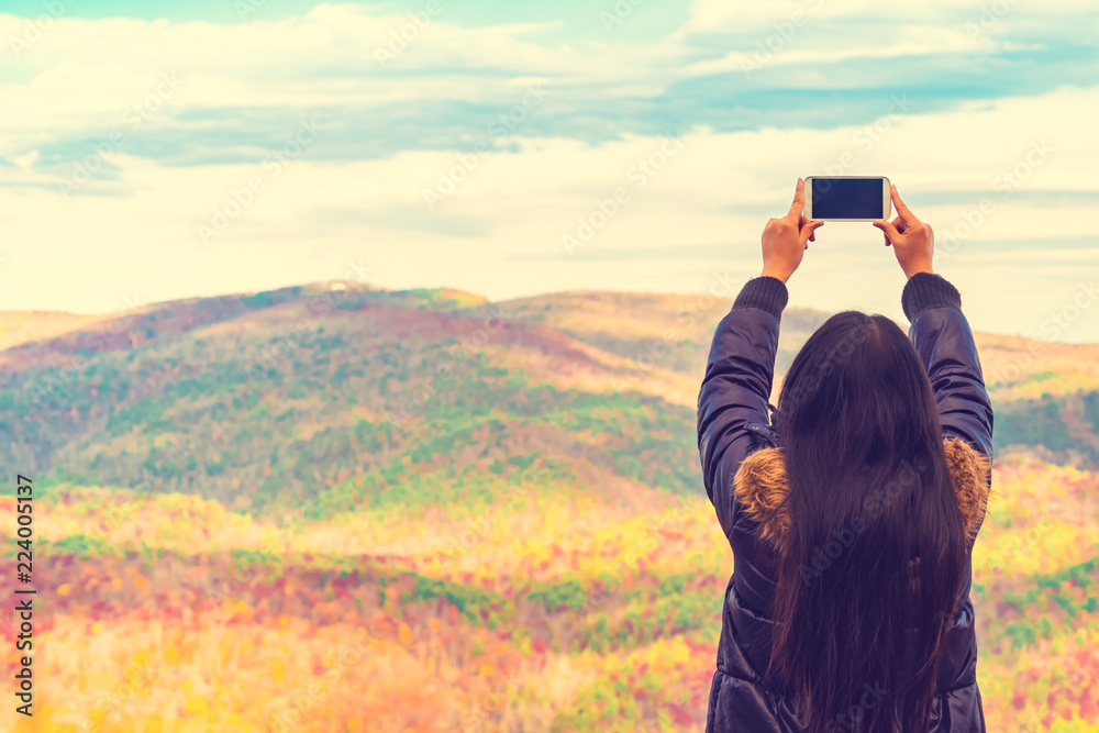 Woman taking a photo high above the mountains