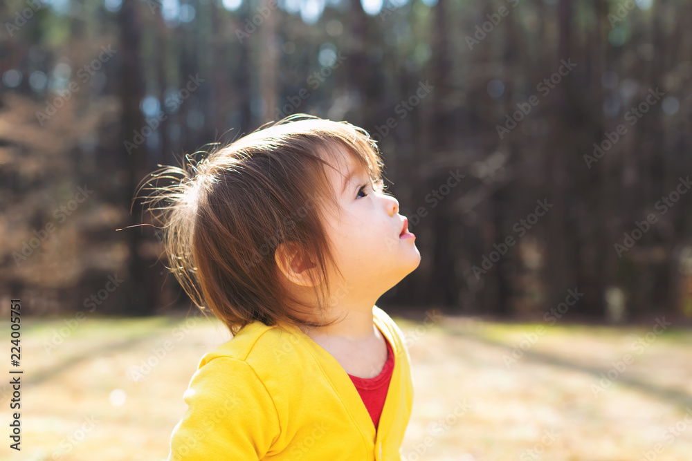 Happy asian toddler boy playing outside on a sunny day