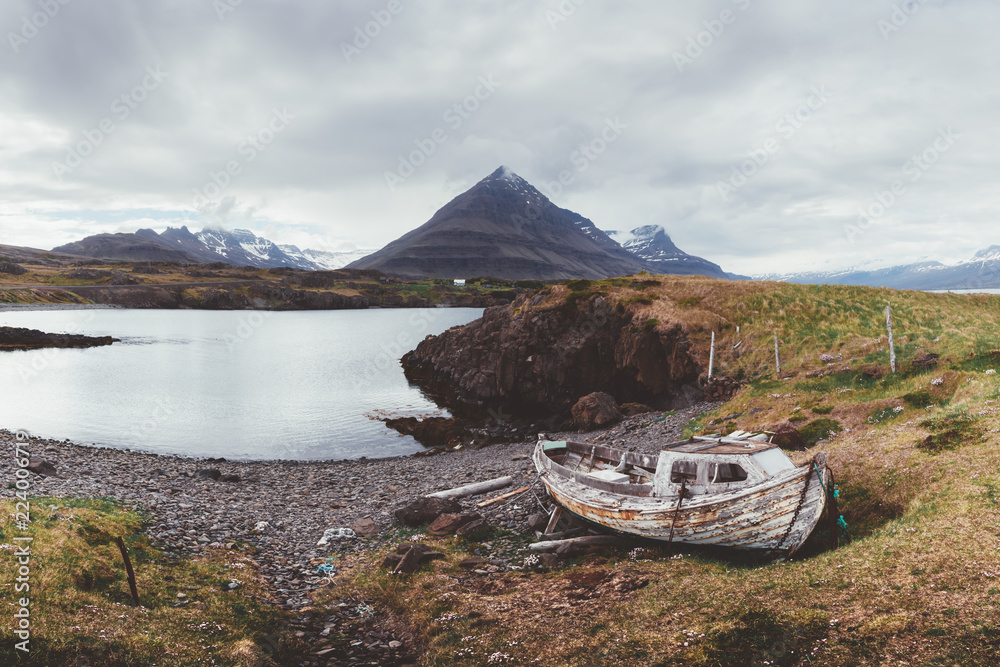 Typical Iceland landscape with fjord, mountains and old ship