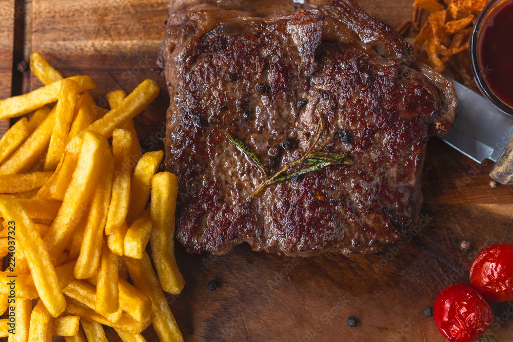 großes Rinder Steak mit Pommes vom BBQ Grill auf einem Holzbrett auf dem Oktoberfest serviert in Bay