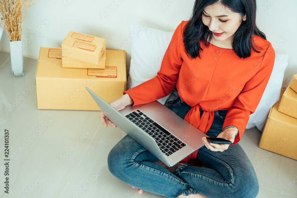 Young asian girl is freelancer with her private business at home office, working with laptop, coffee