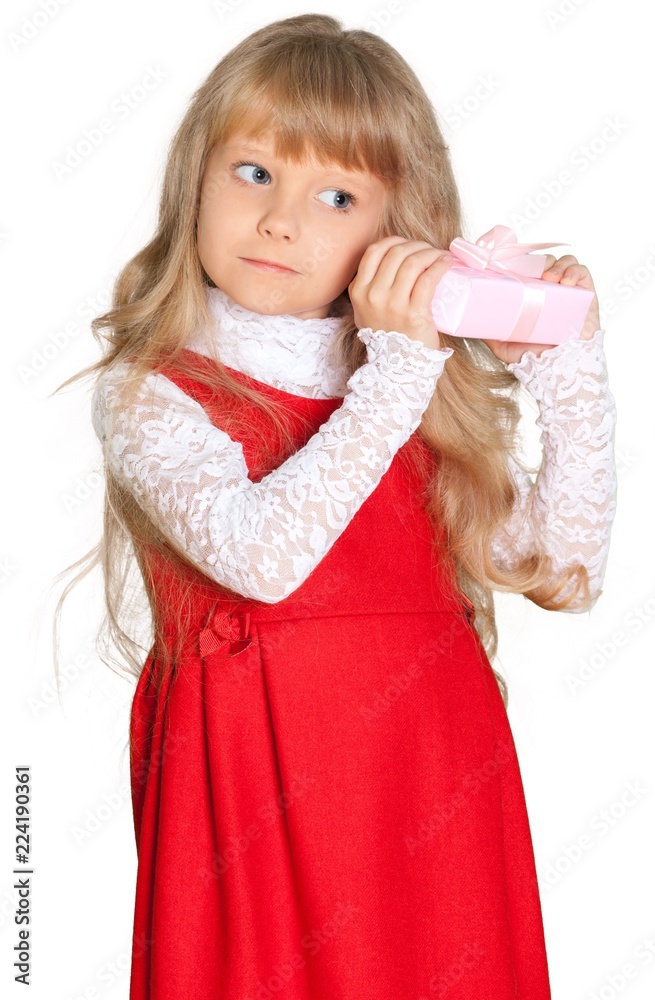 Little blonde girl in a red dress with a gift in a pink package