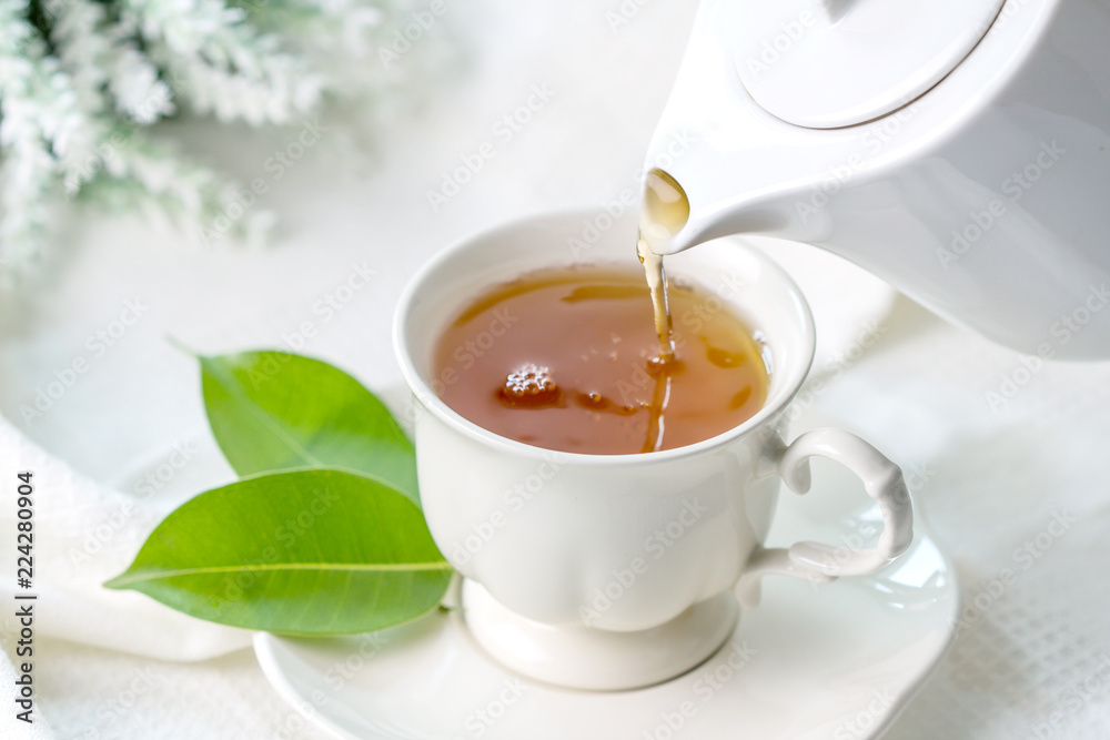 Close up pouring hot black tea in a white tea cup ,  Tea ceremony time concept