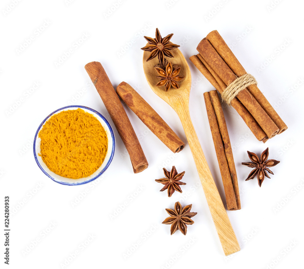 Close up the brown cinnamon stick and powder with star anise spice in wooden spoon isolated on white