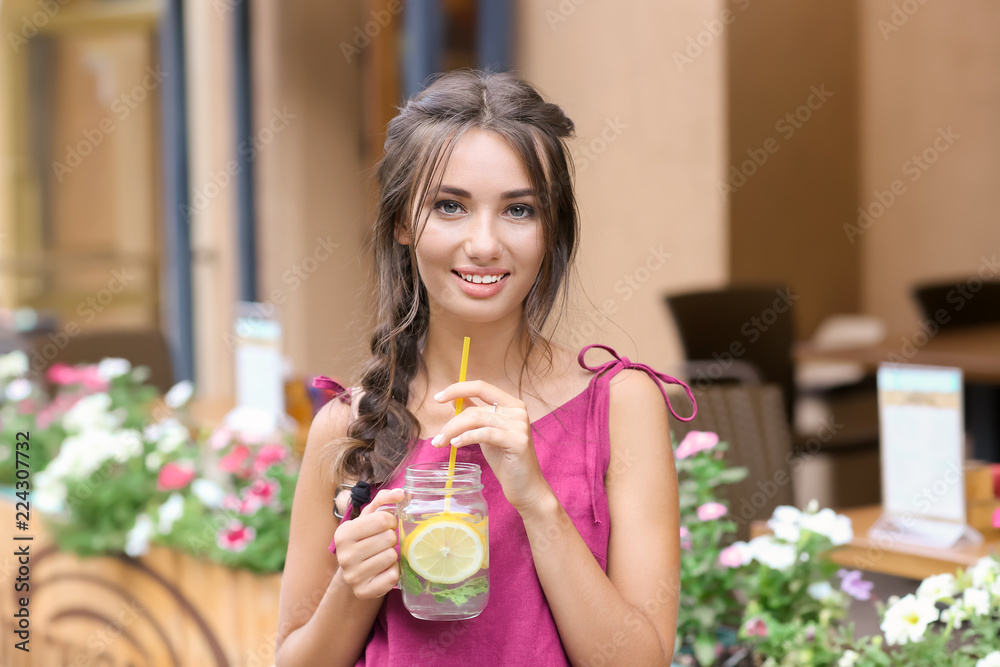 年轻女子在户外拿着一罐新鲜柠檬水