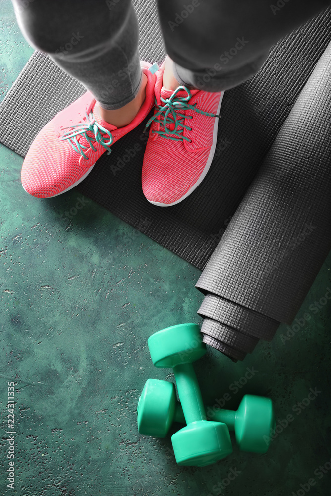 Sporty woman standing on yoga mat