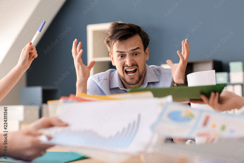 Stressed worker sitting at table in office