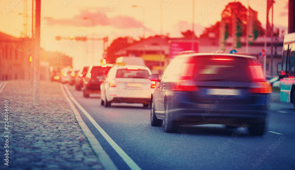 Cars moving on the road in city in late evening. View to the traffic with trafficlights and transpor