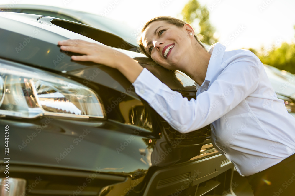 Car seller woman hugging car at the garage