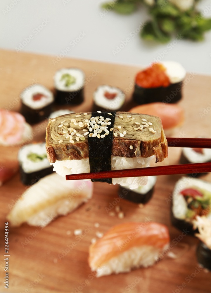 Chopsticks with Nigri Sushi and Sushi Plate in Background