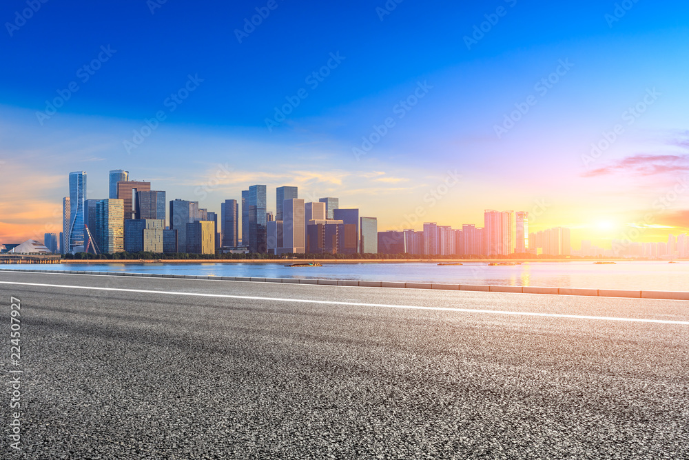 Urban asphalt road and modern buildings in Hangzhou at sunrise