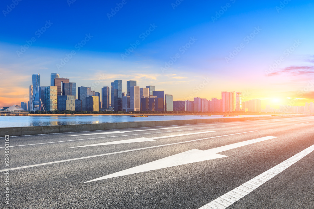 Urban asphalt road and modern buildings in Hangzhou at sunrise