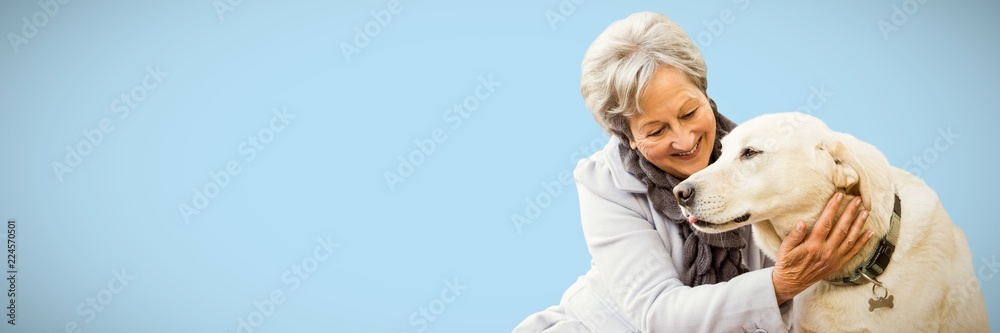 Composite image of senior woman holding a dog