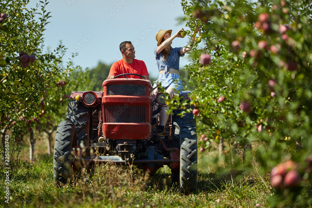 Farmers couple driving tractor