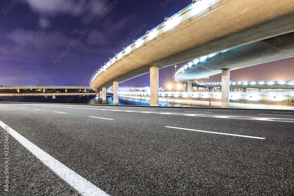 夜晚的沥青路和现代桥梁建筑风光