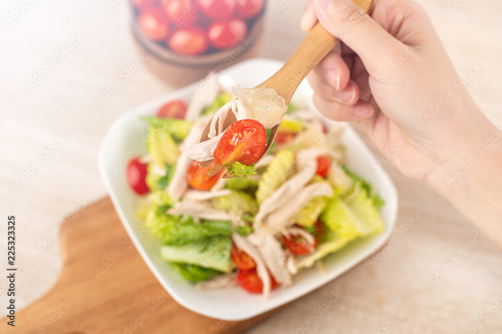 Fresh and delicious homemade chicken salad with tomatoes and pomelos in wooden background, concept o