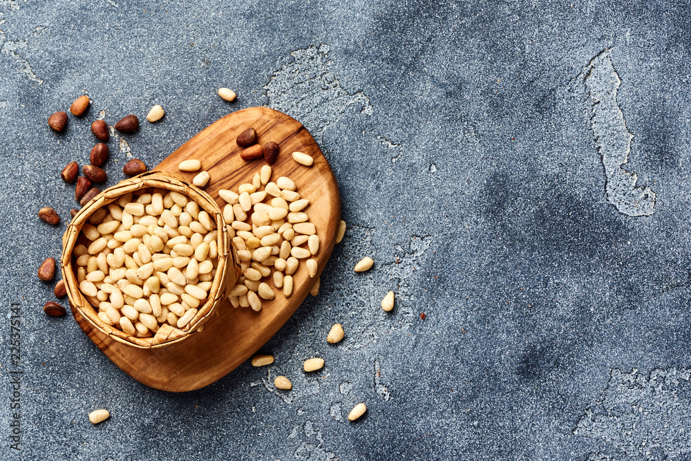 Peeled pine nuts with copy space on gray background. Top view.