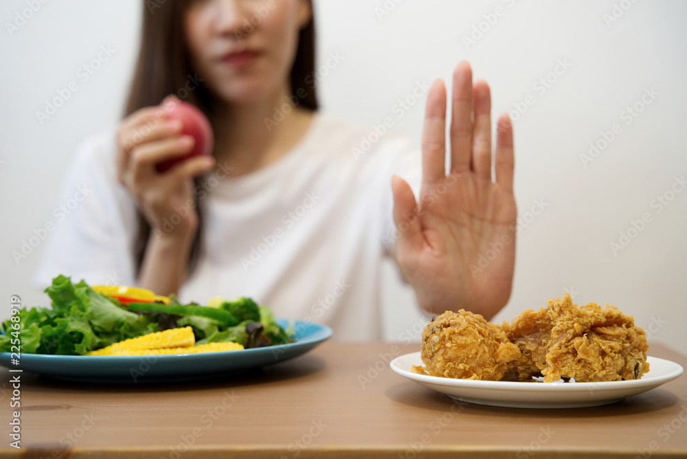 年轻女孩为了健康而节食。特写女性用手推垃圾食品