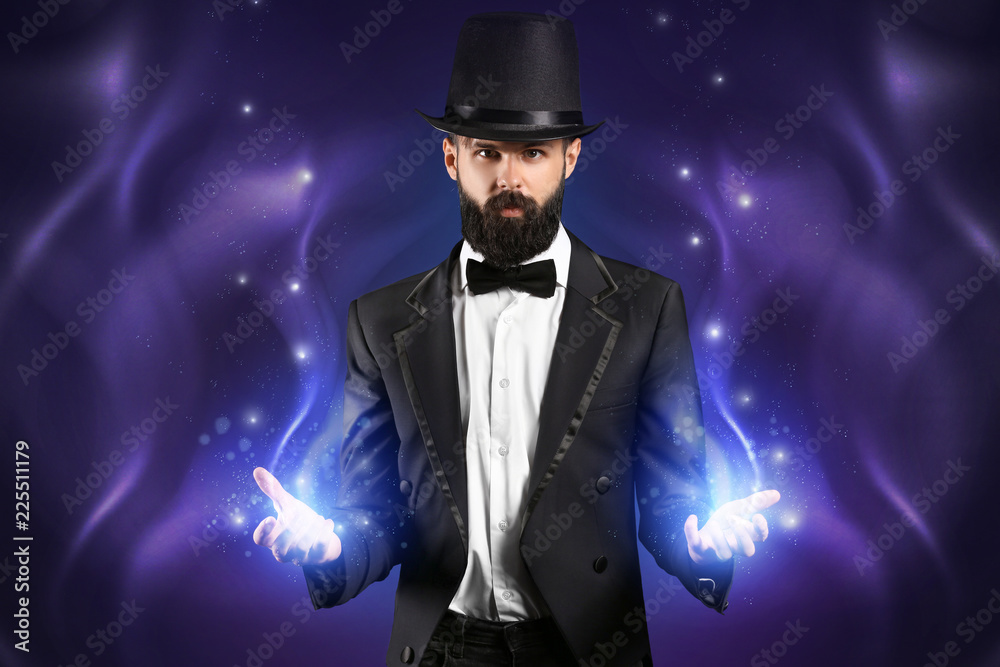 Male magician on dark background