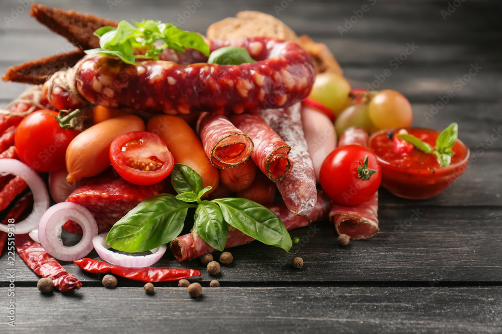 Different kinds of sausages on dark wooden table