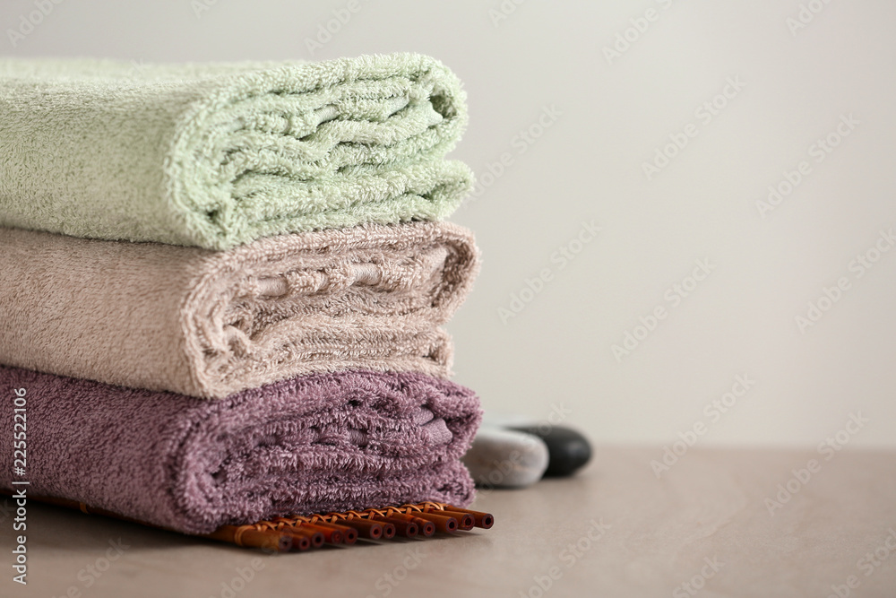 Stack of clean soft towels on bamboo mat