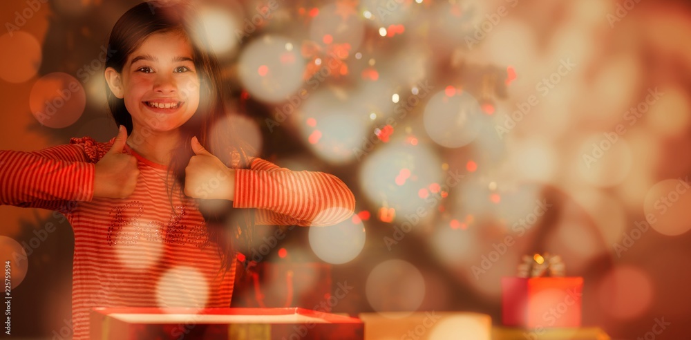 Composite image of little girl opening a glowing christmas gift