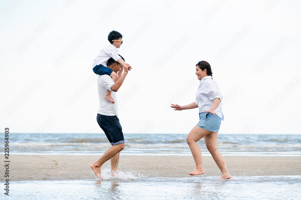 快乐的一家人在夏天去海滩度假。