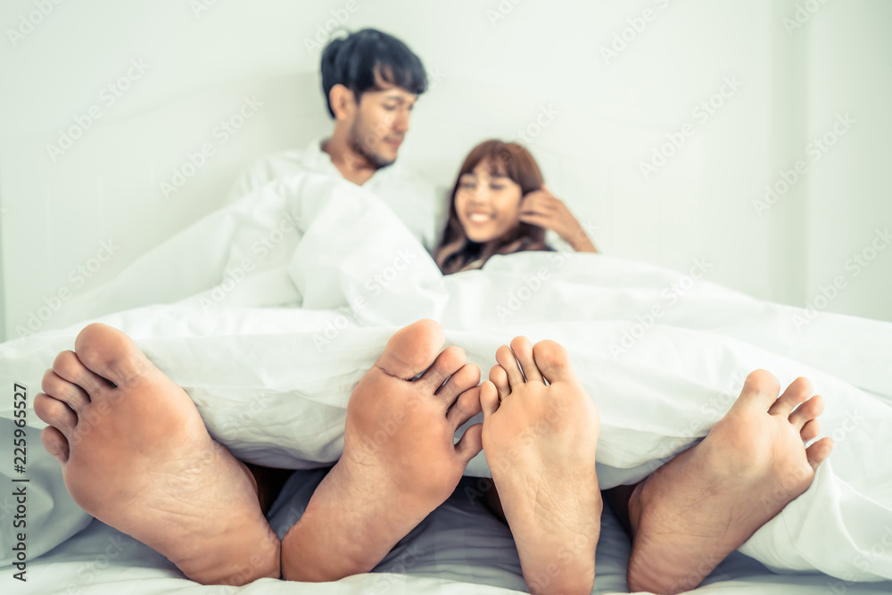 Happy young couple relaxing in the home bedroom.