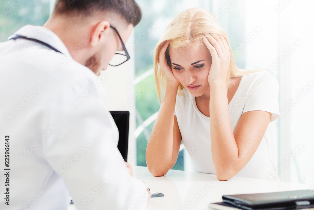 Male Doctor and Female Patient in Hospital Office