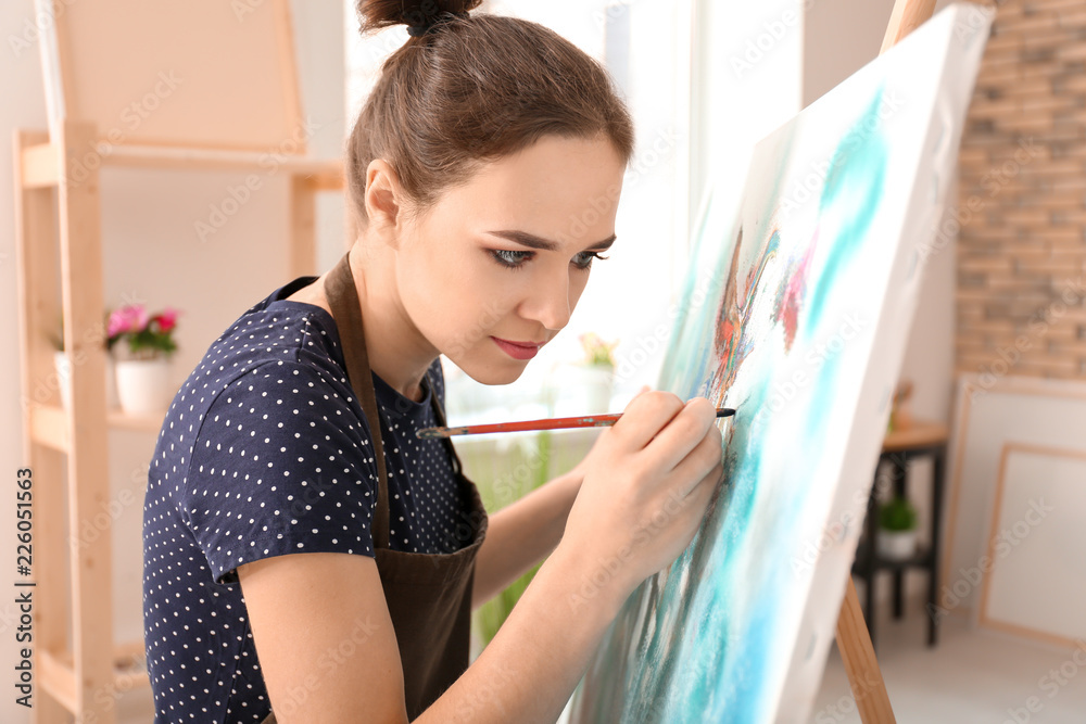 Female artist painting picture in workshop