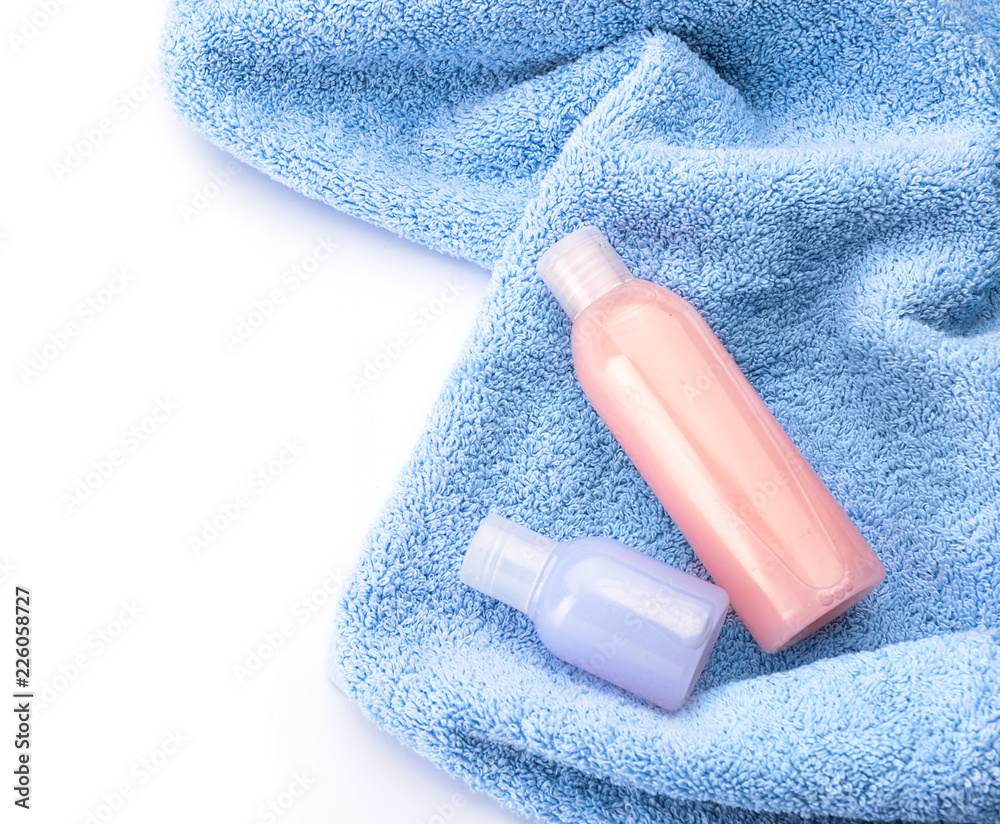 Clean soft towel and cosmetics on white background, top view