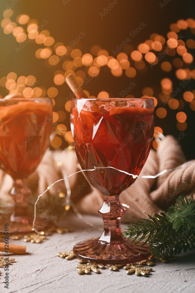 Glasses of delicious mulled wine on grey table