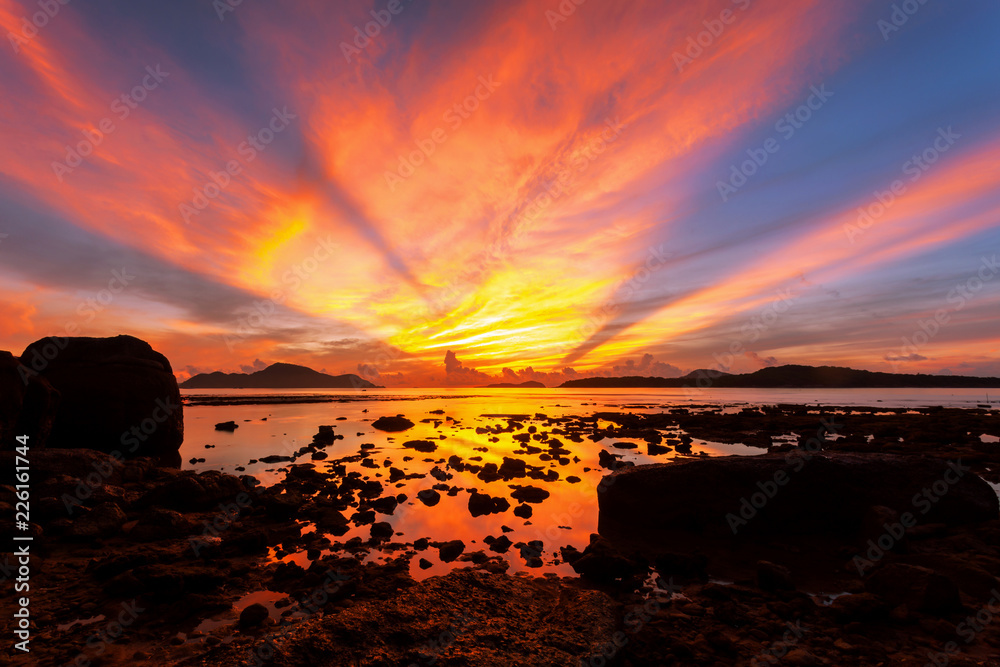 热带海面上美丽的灯光和戏剧性的天空景色，水中倒影，美丽的日出