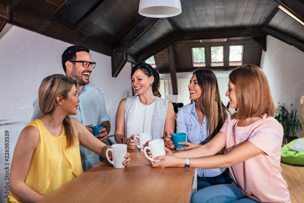 Friends or coworker having fun while drinking tea at counter table.