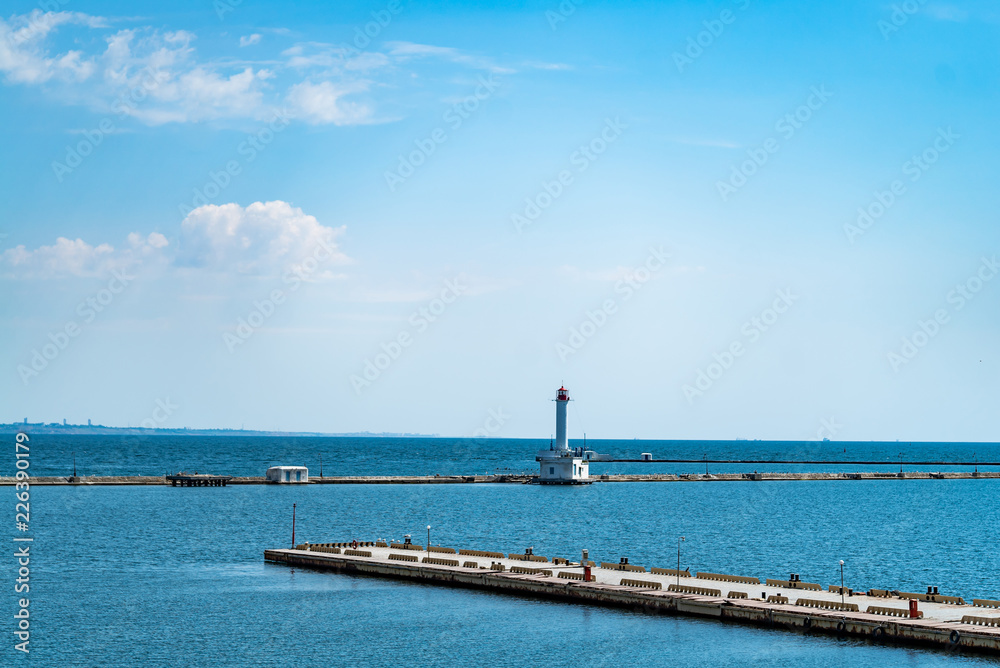 夏日灯塔背景下的码头海景。美丽的风景