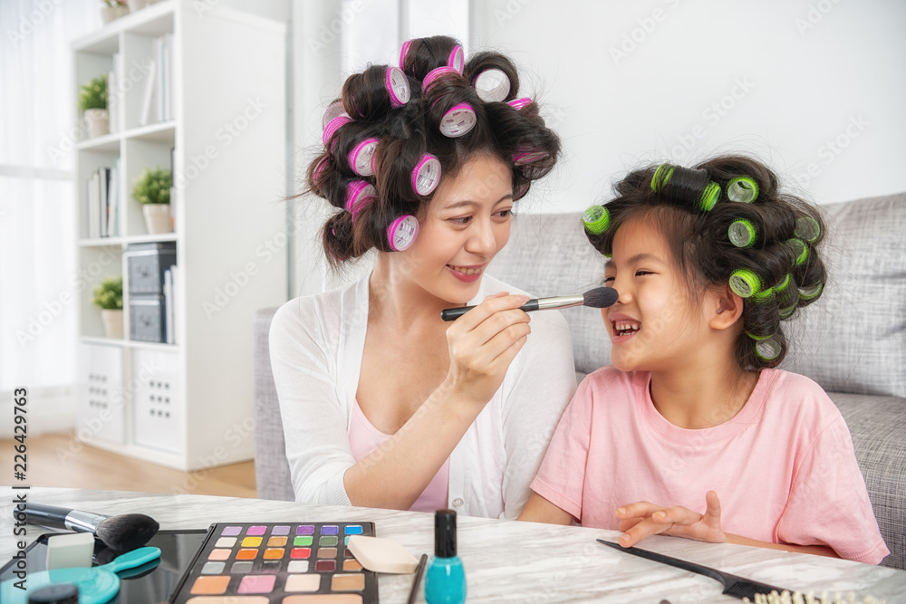 beautiful mom painting her cute daughters face