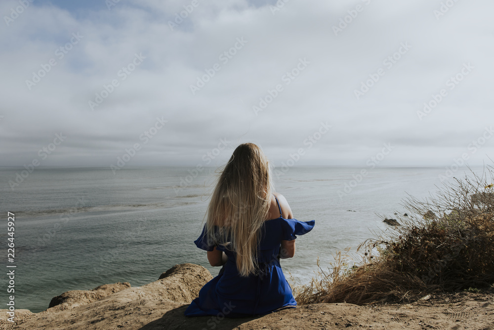 A woman sitting alone at a beach