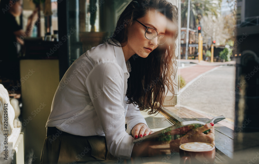 Woman reading book at coffee shop