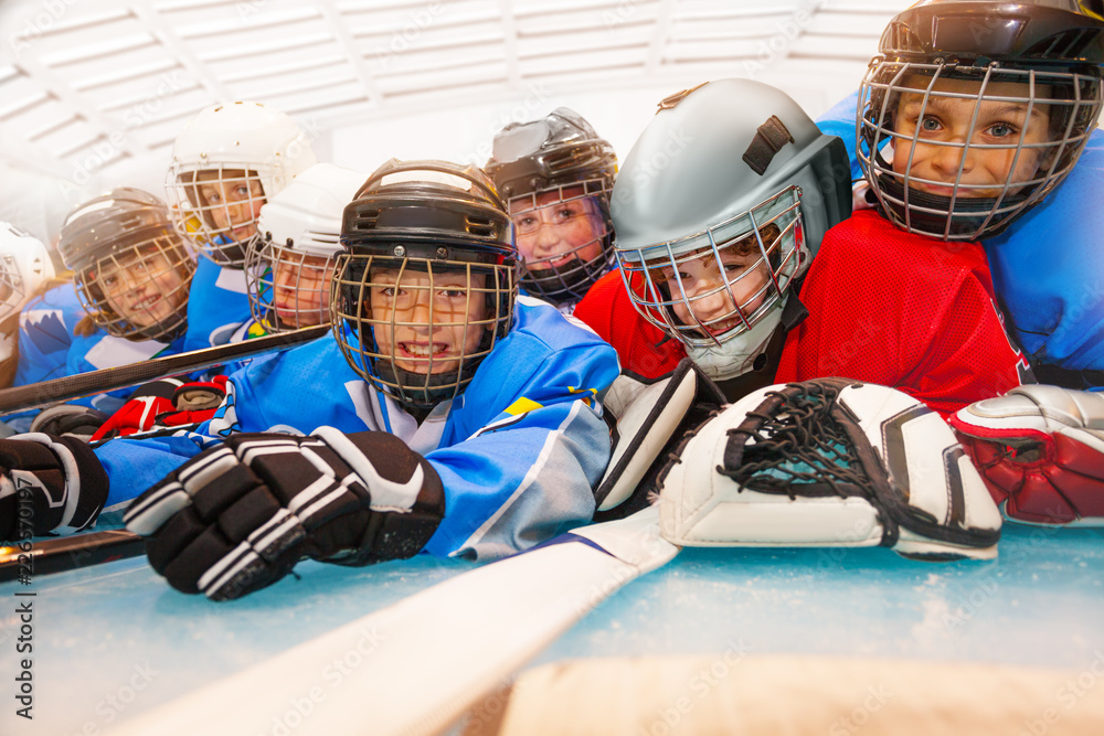 Cute boys in hockey uniform laying on ice rink