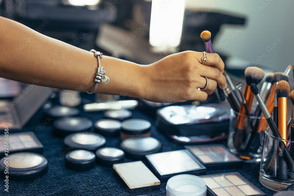 Close up of hand of makeup artist picking up a makeup brush